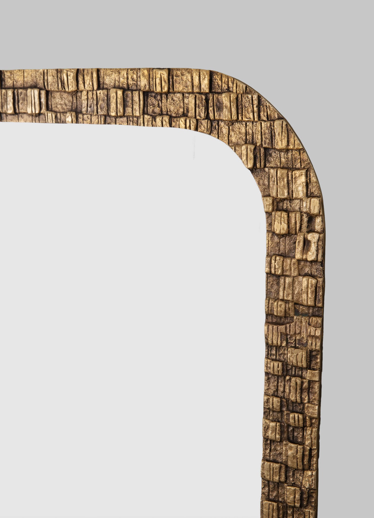 A wooden mirror frame with a textured, square pattern in a warm, natural wood tone. The frame features a rounded corner and a rustic, handcrafted style.
