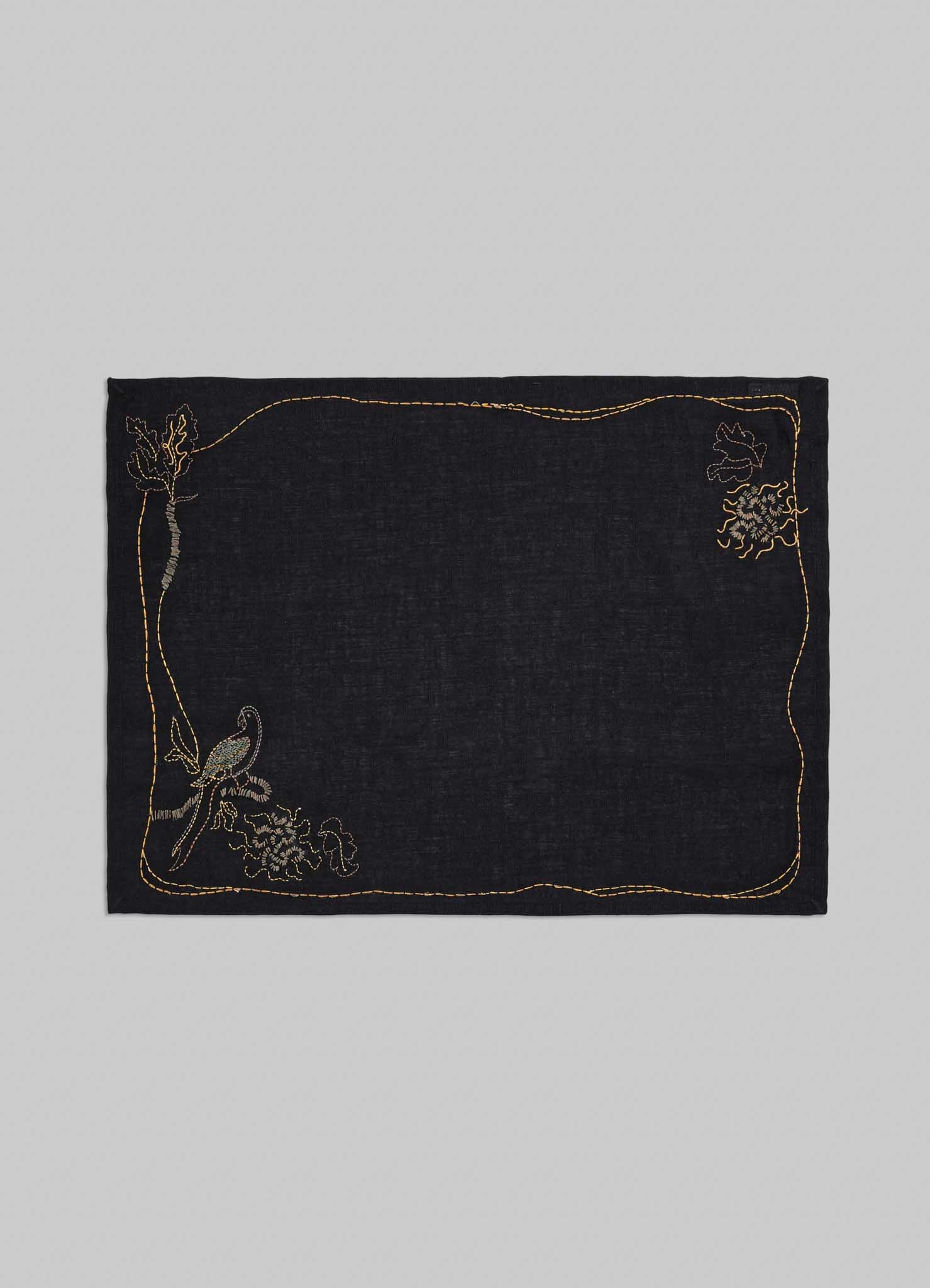 Black fabric square with gold embroidery on a gray background viya placemats