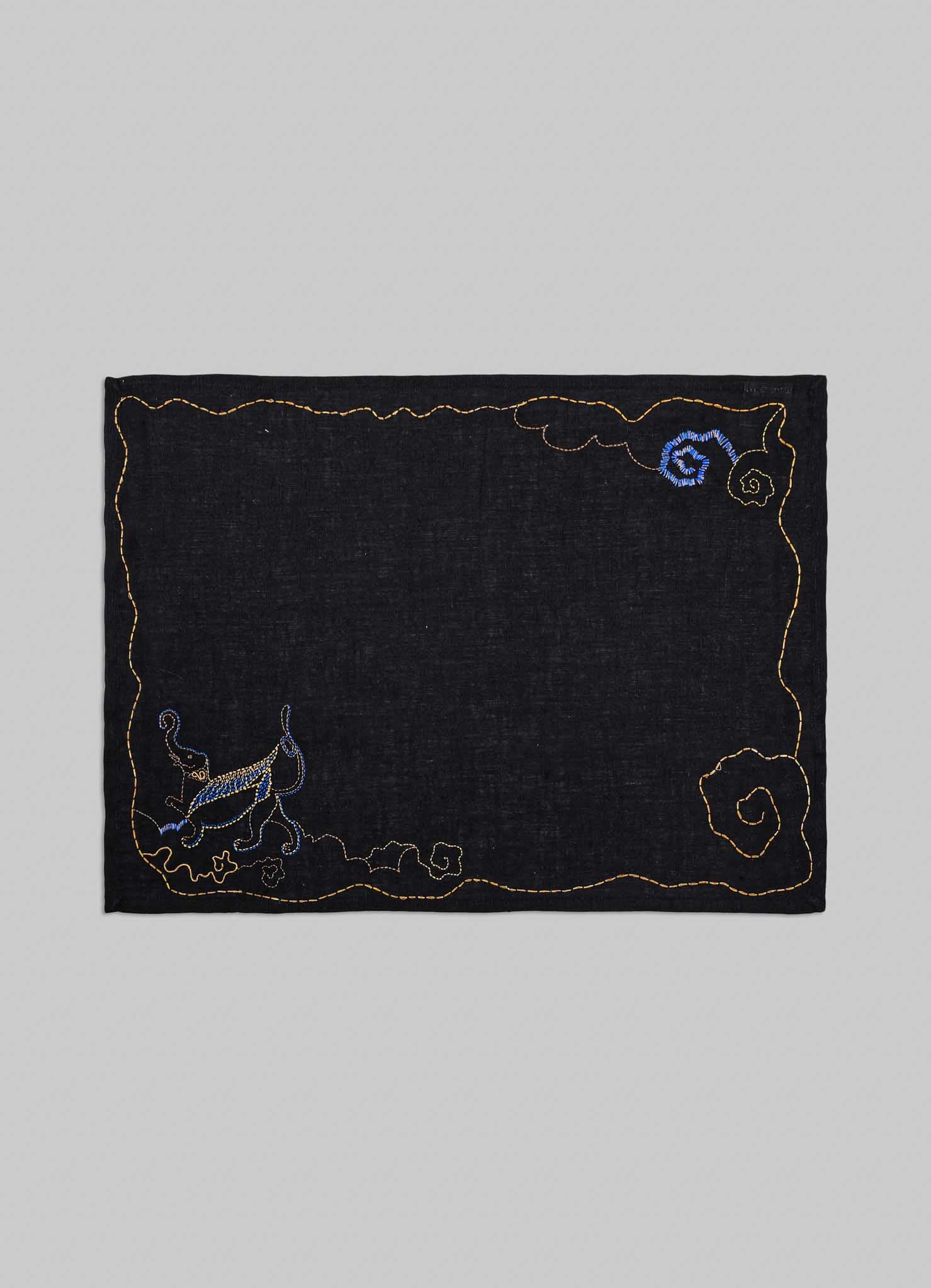Embroidered black fabric patch with decorative elements on a gray background viya placemats