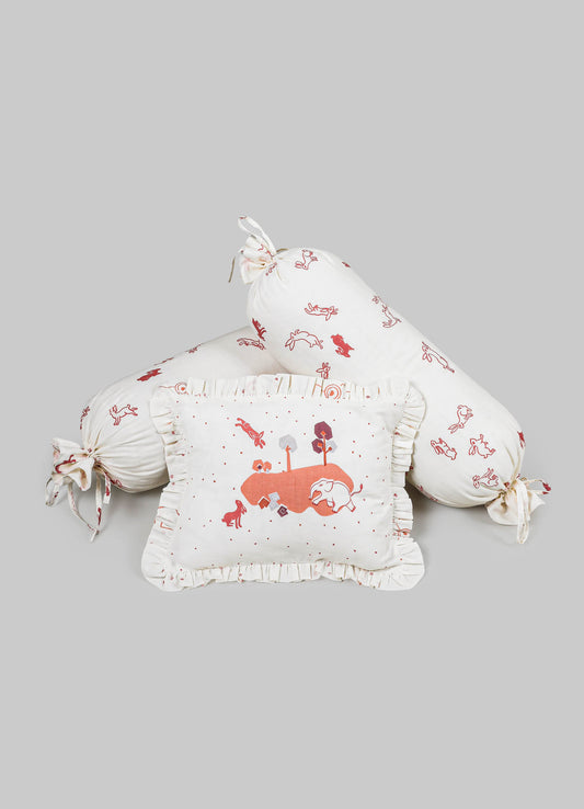 Children's bedding set comprising a ruffled pillow with an illustrated landscape, a long bolster pillow with tied ends, and a square cushion, all made of soft cotton fabric with whimsical animal and nature motifs in shades of red and pink.