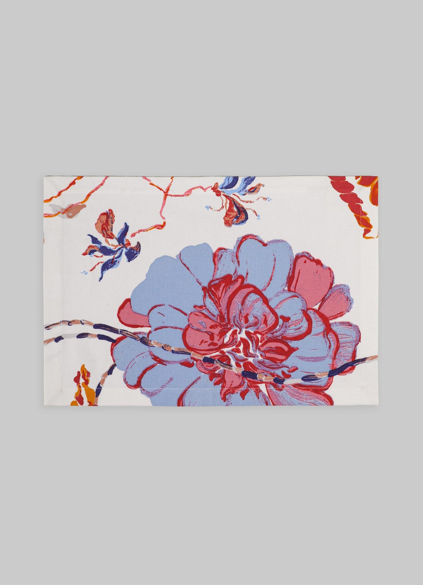 Fabric table runner with an abstract floral pattern in shades of blue, red, and orange on a white background. Made of cotton or similar material, with a contemporary style and vibrant, painterly motifs.
