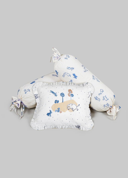 Cotton bedding set with printed animal motifs in blue and beige, including a square cushion and two cylindrical bolster pillows with tied ends. The fabric features playful illustrations and ruffled trim details.