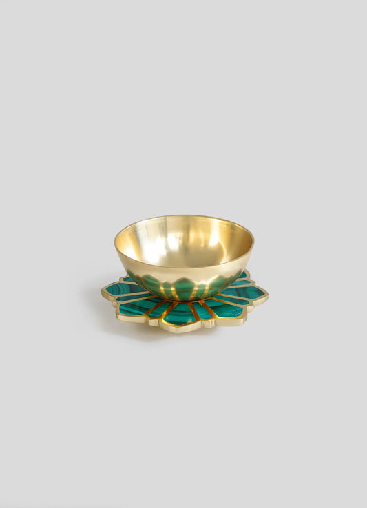 A decorative bowl with a gold metallic interior and a green malachite-patterned exterior, placed on a matching gold and green floral-shaped tray.