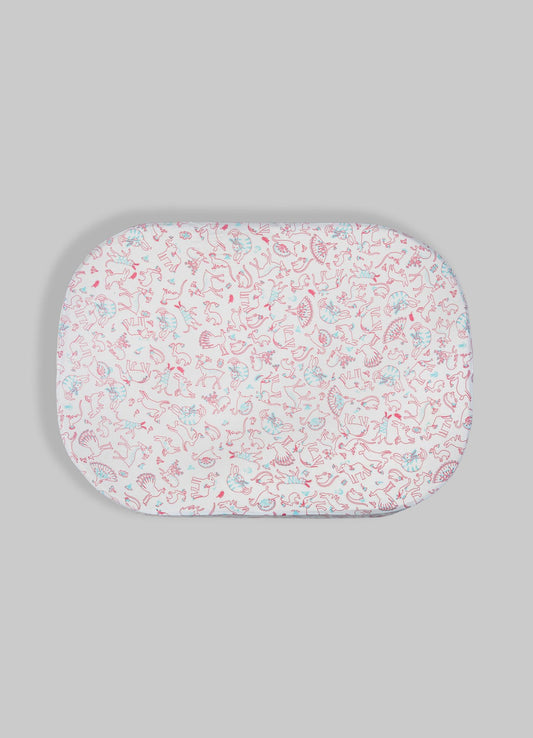 Oval fabric tray with a white background and a pattern of pink and light blue animal motifs, including rabbits and other creatures, on a neutral gray surface.