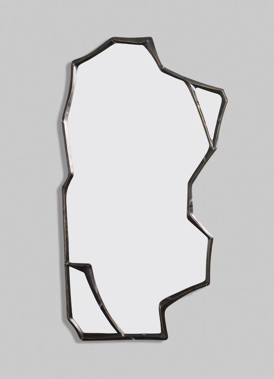 A decorative wall mirror with an irregular, geometric metal frame in dark bronze or black finish, set against a light-colored wall. The mirror has an abstract, contemporary style with angular lines and a minimalist appearance.