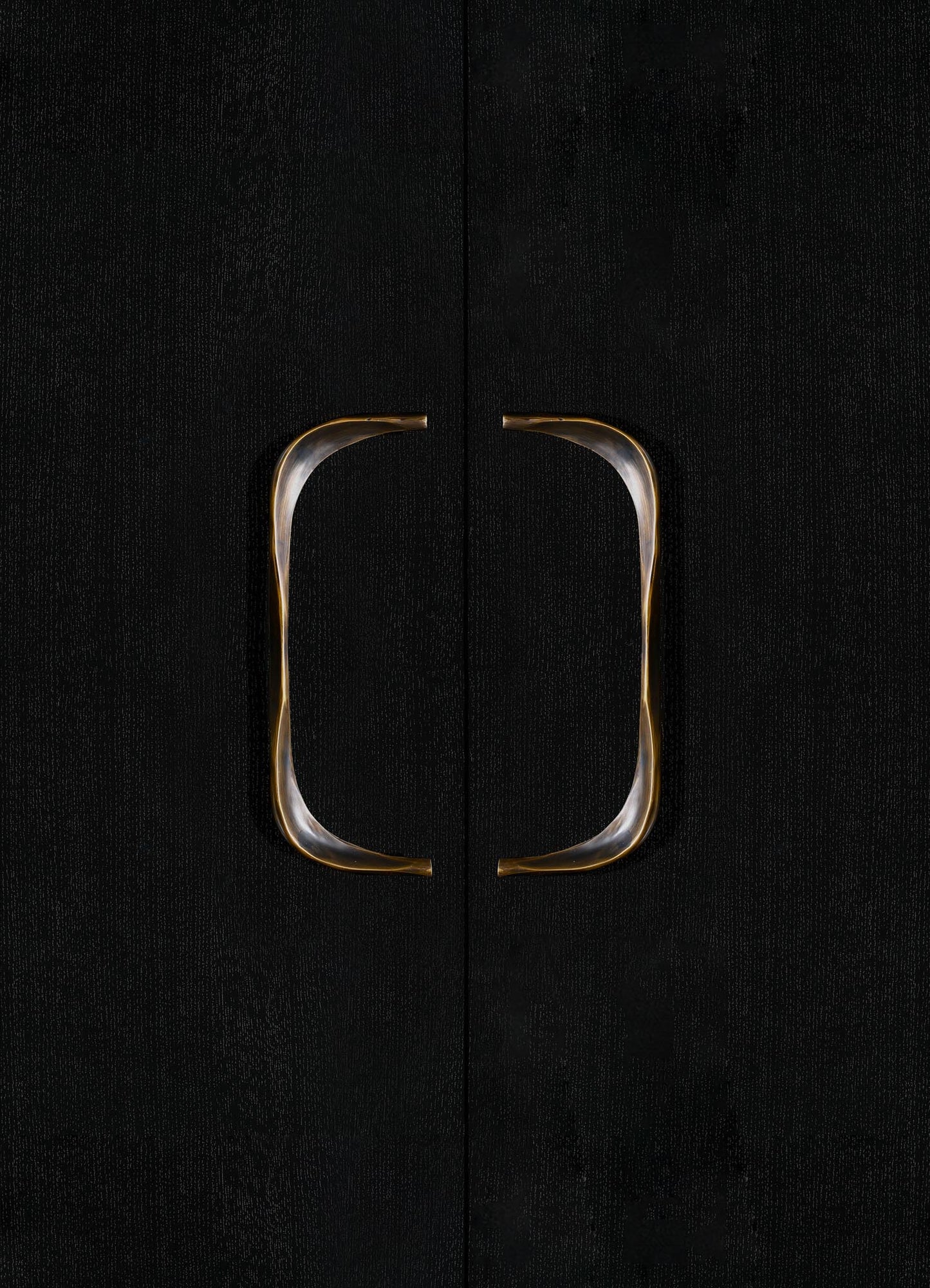 Black textured cabinet doors with metallic gold and silver curved handles.