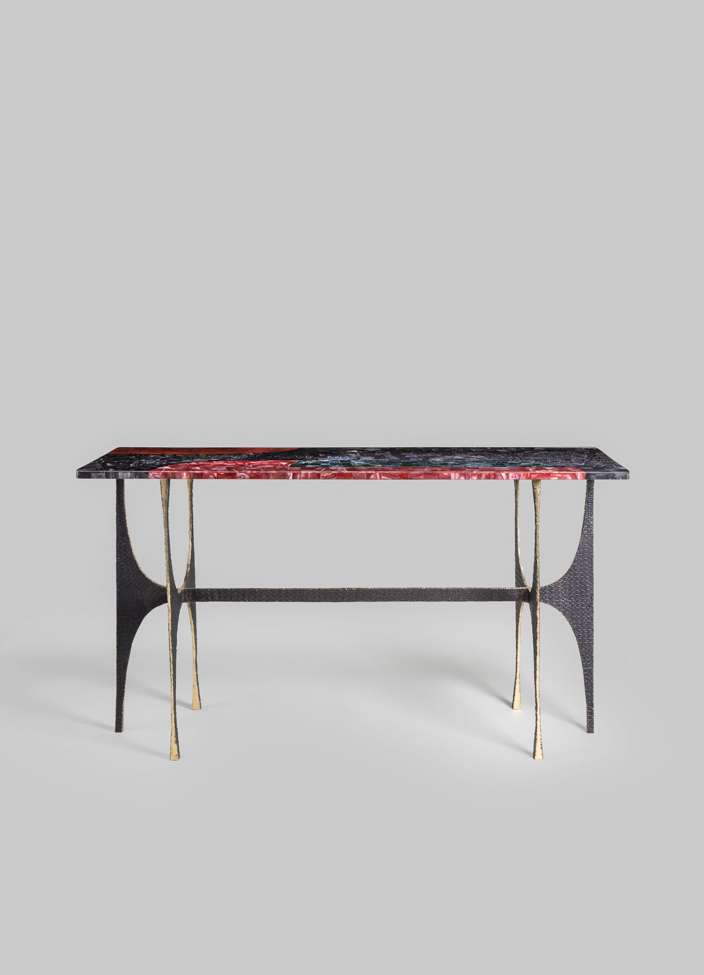 A rectangular table with a marble top featuring red, black, and green veining, supported by black and gold metal legs with curved details, in a contemporary style.