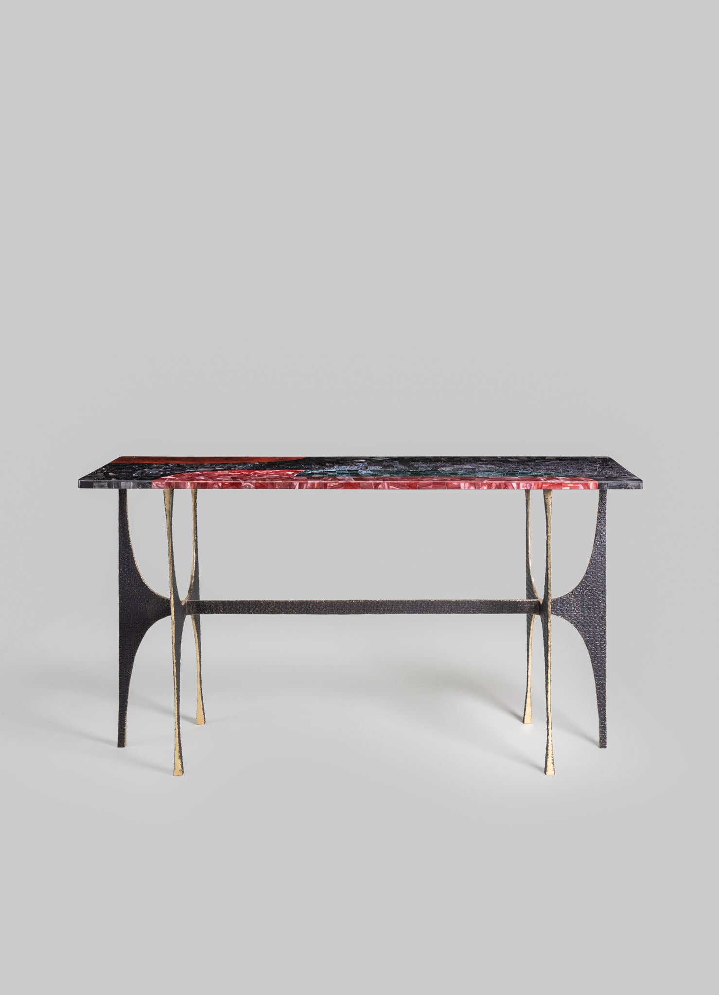 A rectangular table with a marble top featuring red, black, and green veining, supported by black and gold metal legs with curved details, in a contemporary style.