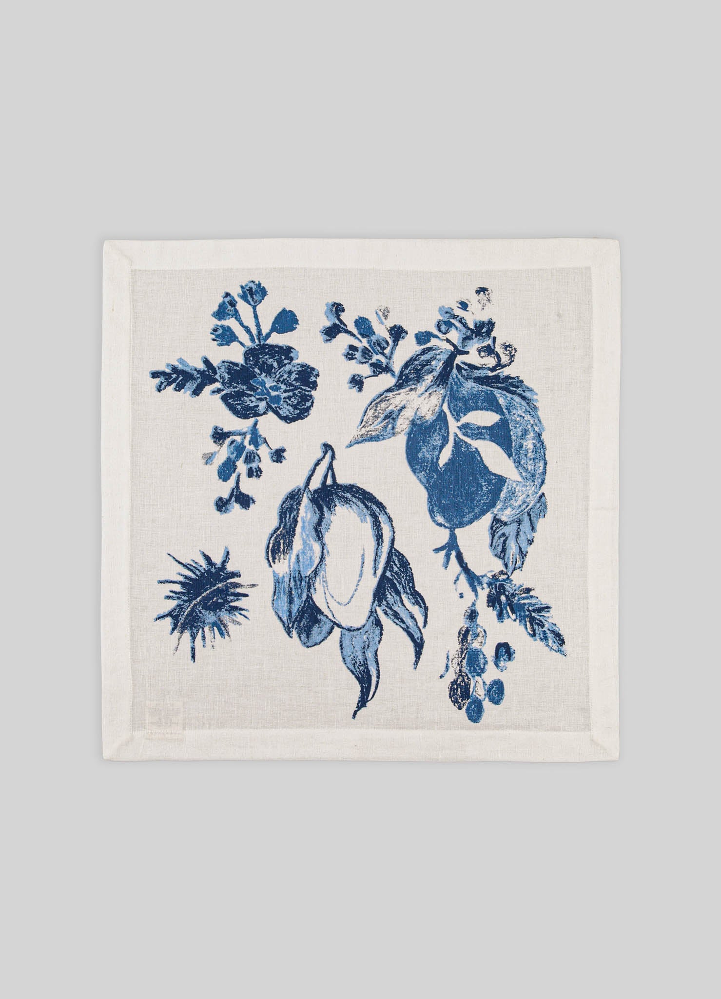 A square textile featuring a blue and white botanical print with floral and leaf motifs, likely made of cotton or linen. The design has a classic, handcrafted style with a natural, light background tone.
