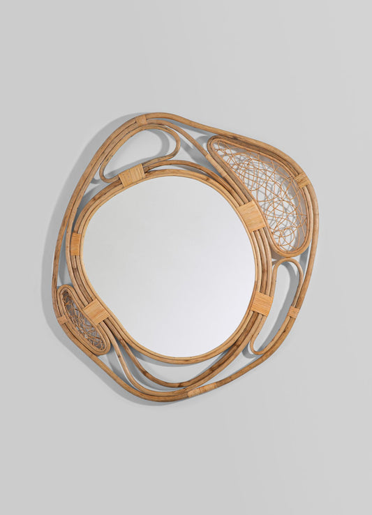 Rattan wall mirror with an abstract, swirling frame and intricate woven details, finished in natural wood tones.