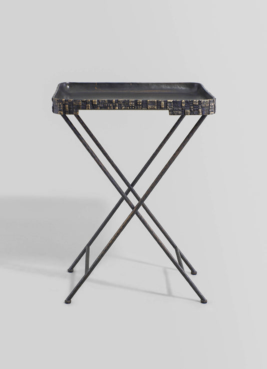 A black metal tray with a textured, geometric pattern on the edge, supported by a slender, intersecting X-shaped metal frame, presented against a plain background.