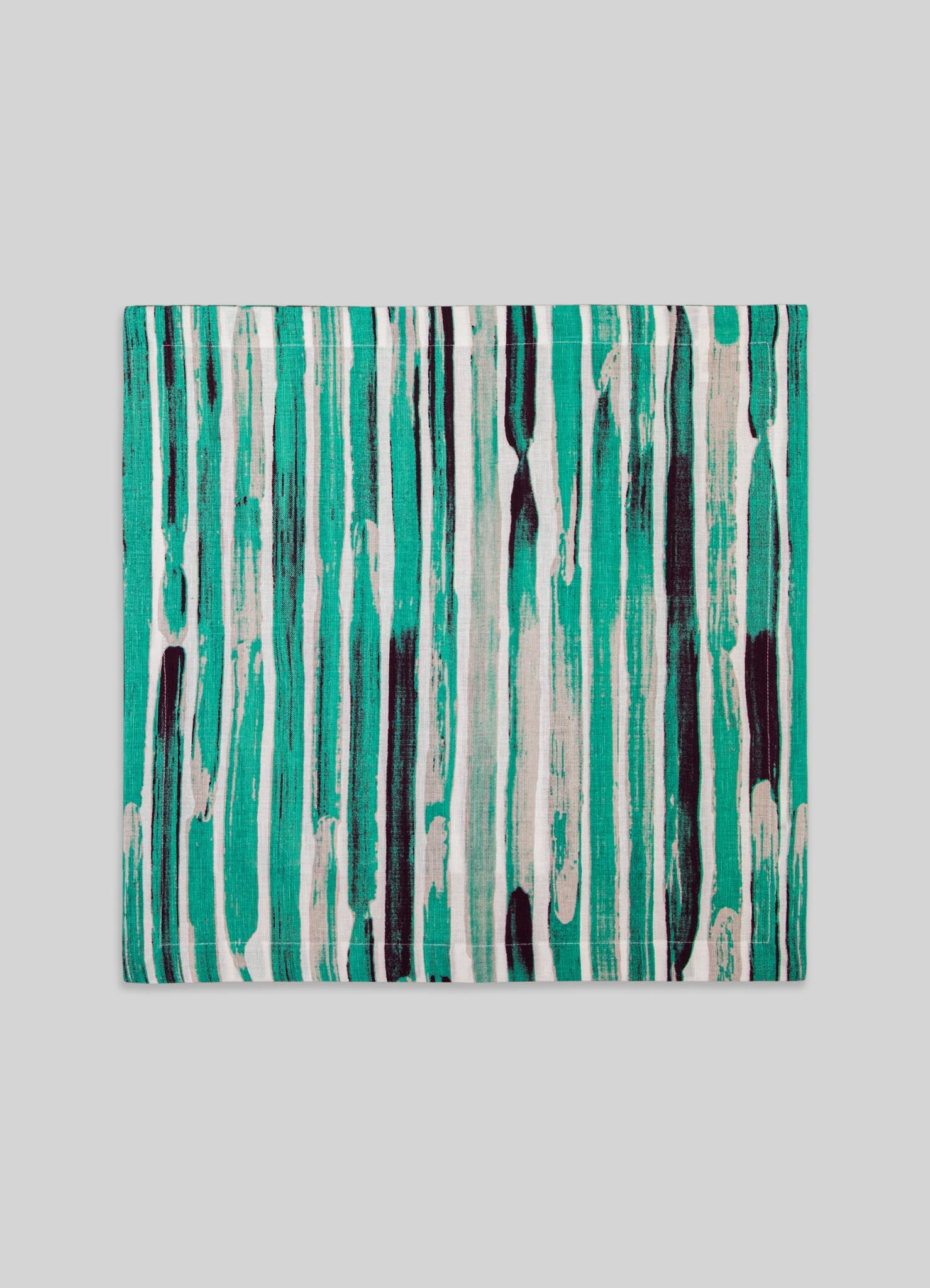 A rectangular table runner made of fabric featuring a vibrant abstract pattern of vertical brushstrokes in shades of turquoise, black, and white, set against a neutral gray background.
