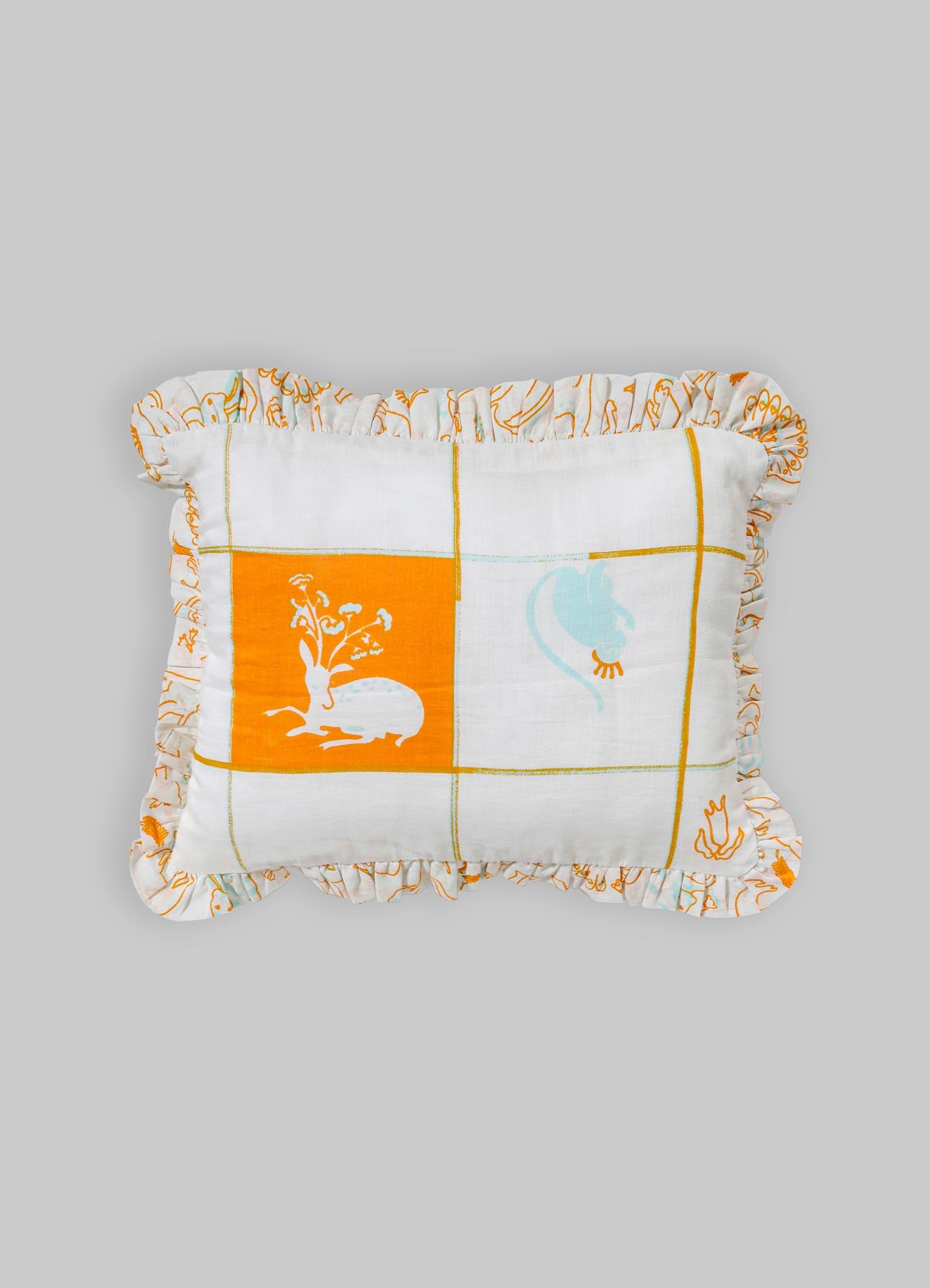 A decorative cushion made of lightweight fabric with a patchwork design featuring orange, white, and blue hues. The cushion has a ruffled border with embroidered patterns and a central motif of a rabbit and floral elements.