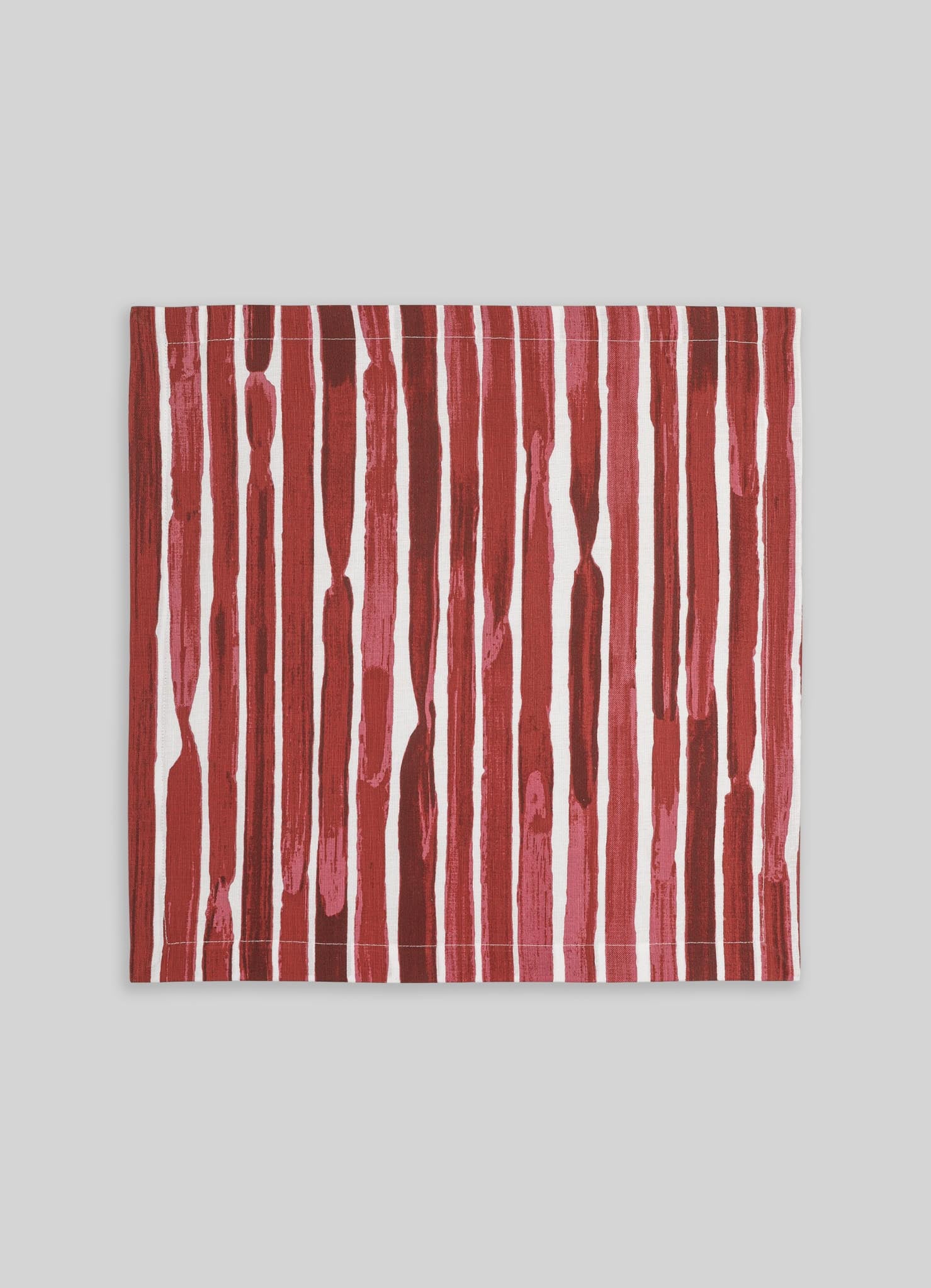 A rectangular fabric with vertical brushstroke pattern in shades of red, pink, and white. The design has an abstract, hand-painted look, suitable for use as a textile or decorative piece.