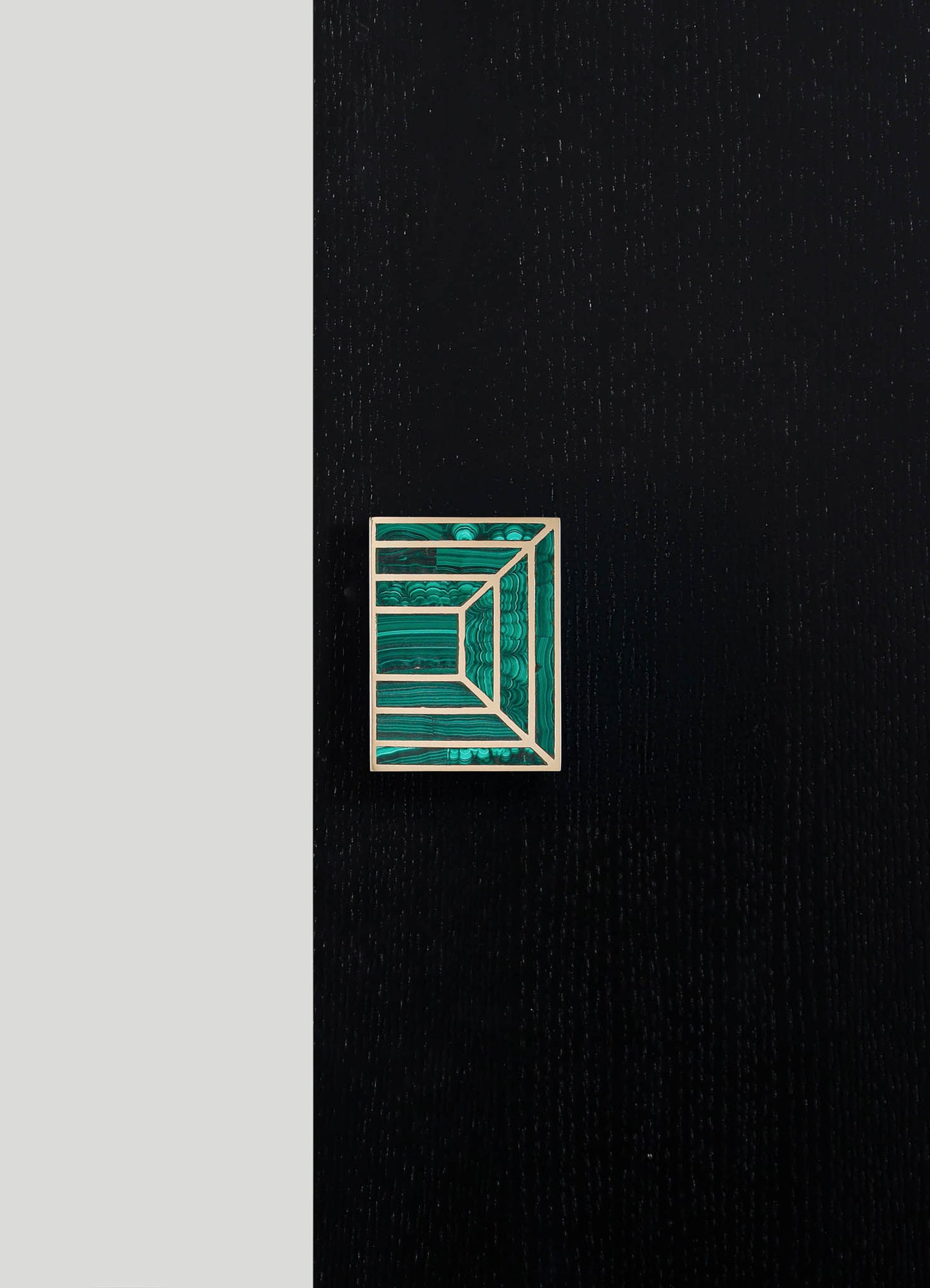 A geometric brooch with a rectangular shape, featuring layered, concentric lines in shades of teal and turquoise, mounted on a black textured surface.