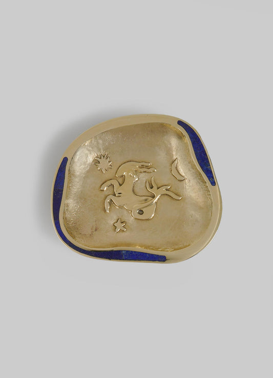 A decorative metal dish with a gold-toned finish, featuring an engraved zodiac horse motif and accented with cobalt blue enamel border details.