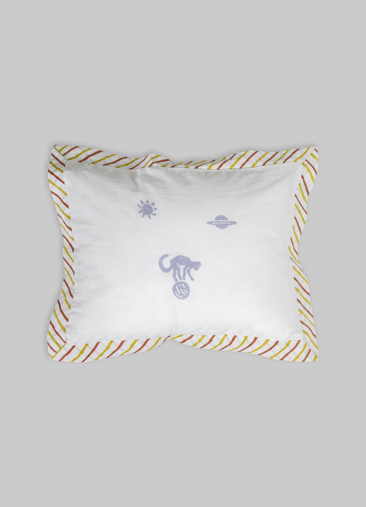 Decorative rectangular pillow with white cotton fabric, featuring embroidered motifs of a cat, a sun, and a planet, bordered by a multicolored striped pattern in red, yellow, and orange.