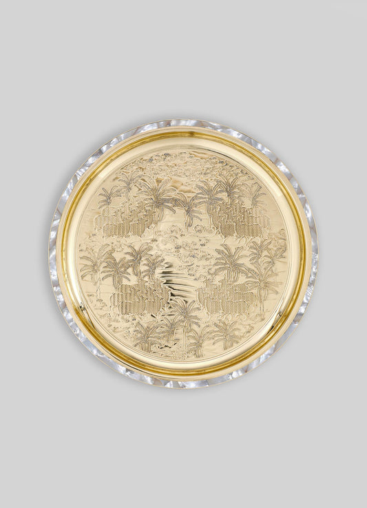 Decorative round tray with intricate engraved landscape and palm tree motifs, crafted from gold-toned metal with a mother-of-pearl and clear shell rim. The tray features a luxurious, handcrafted design with a mix of metallic and iridescent finishes.