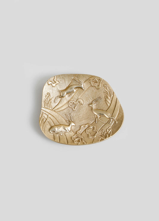 A decorative brass dish with embossed motif of animals and plants, featuring a textured surface and a polished finish.