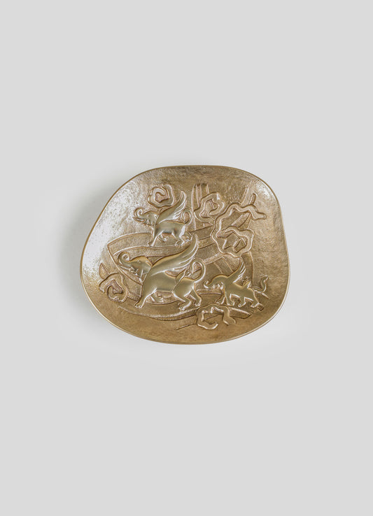 Decorative brass tray with embossed elephant and floral motifs, featuring a textured gold finish on a plain light background.