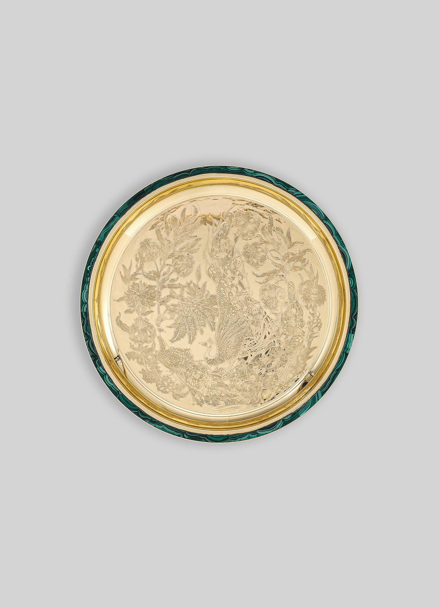 Decorative round tray featuring a detailed engraved design of a peacock amid floral motifs, with a metal gold-tone finish and contrasting emerald green and black marbled edge.