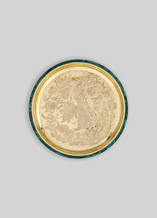 Decorative round tray featuring a detailed engraved design of a peacock amid floral motifs, with a metal gold-tone finish and contrasting emerald green and black marbled edge.