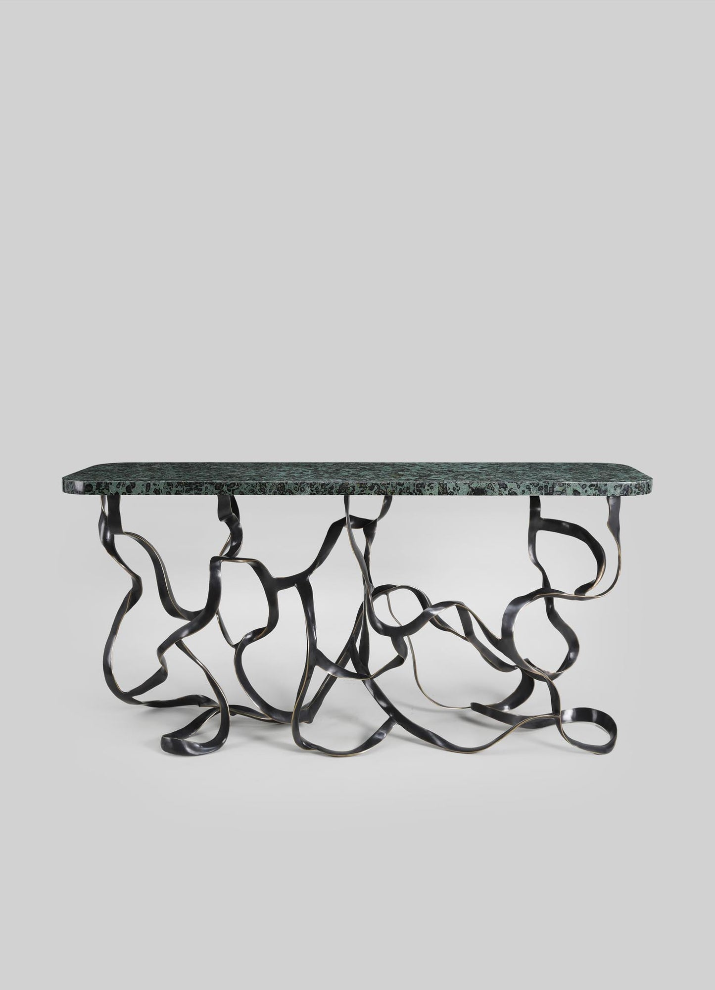 A contemporary table with a green marble top and an abstract, sculptural metal base with a twisted, organic design.