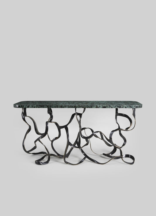 A contemporary table with a green marble top and an abstract, sculptural metal base with a twisted, organic design.