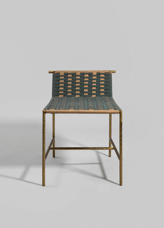 A chair with a gold-toned metal frame and a woven seat and backrest featuring dark and light strips in a geometric pattern. The design combines metallic and woven materials, creating a contemporary and minimalist style.