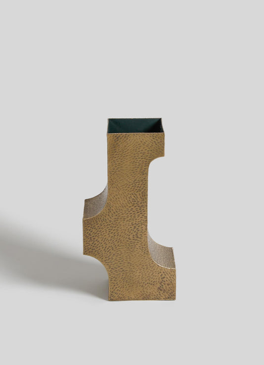A sculptural decorative vase with a metallic gold finish and a textured surface, featuring an abstract geometric shape and a contrasting dark interior.
