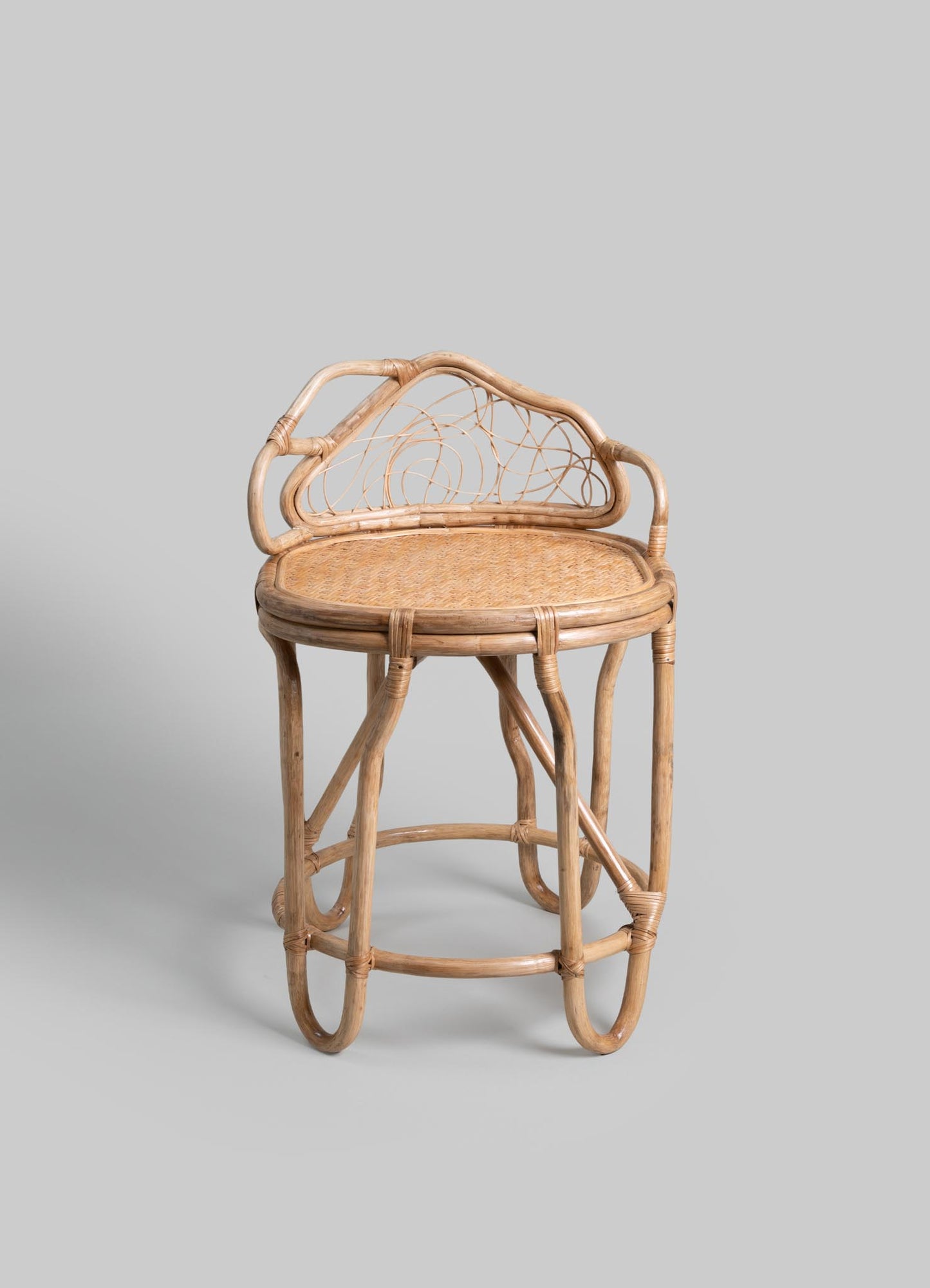 Woven rattan chair with an oval lattice backrest and a natural finish, featuring a round woven seat and curved armrests. The design has a rustic, handcrafted style.
