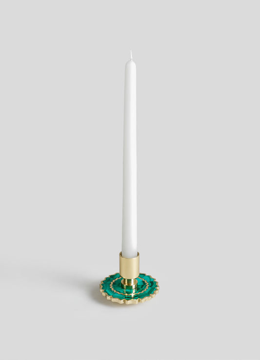 Decorative candle holder with a gold finish, featuring a green and gold layered scalloped ceramic base, holding a tall white taper candle.