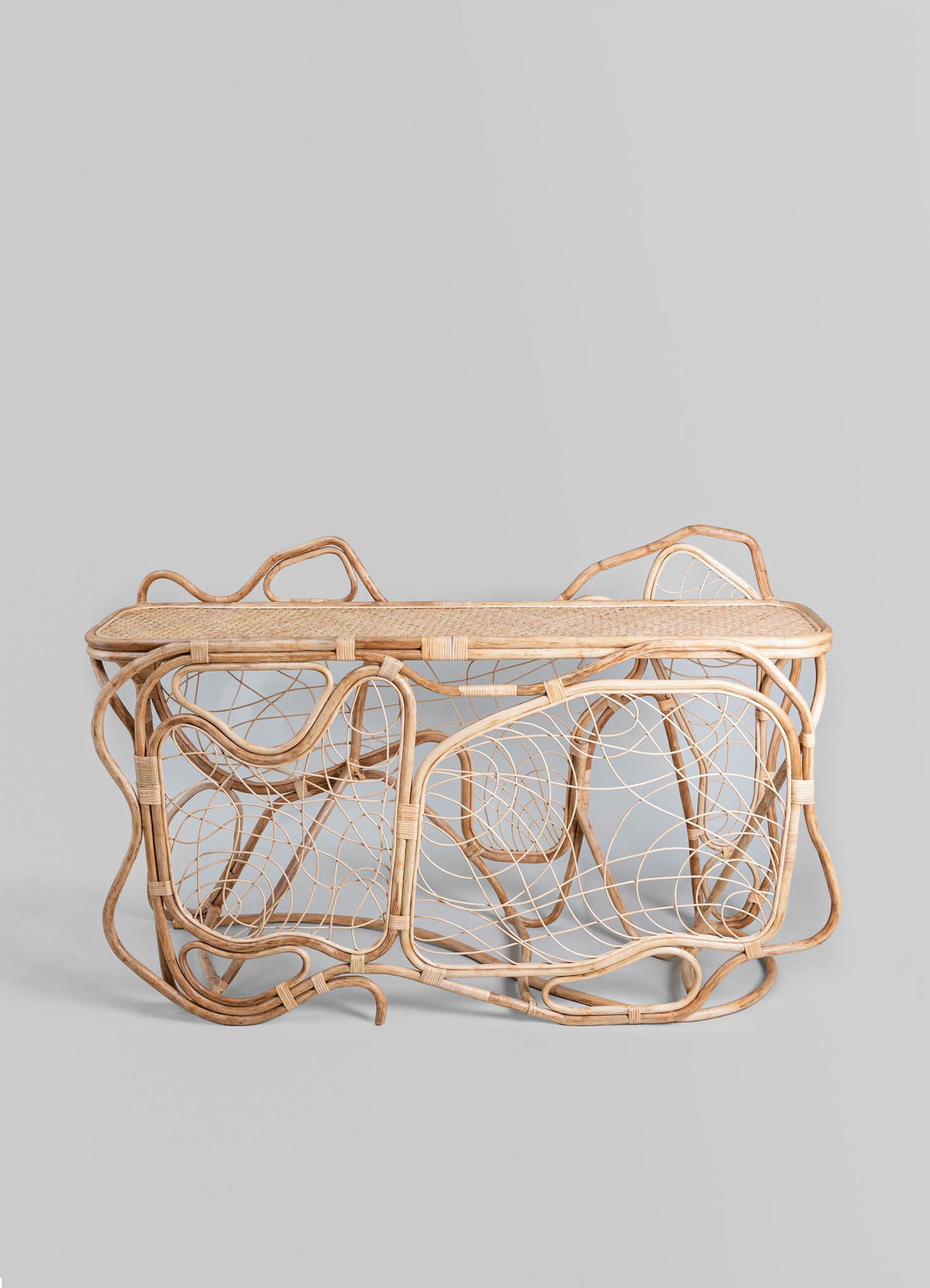 A set of three wicker nesting trays with an intricate, open-weave pattern, crafted from natural rattan. The trays feature a light beige tone and rounded edges, showcasing a handcrafted and rustic style.