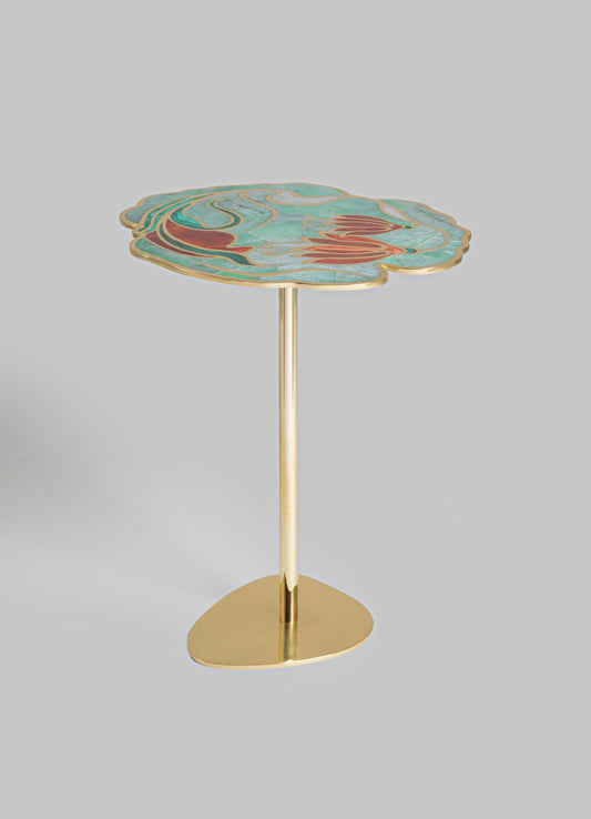 A side table featuring a marble top with a floral motif in shades of turquoise, red, and white, accented with a gold trim. The table has a slender, gold-finished metal stem and a rounded base.