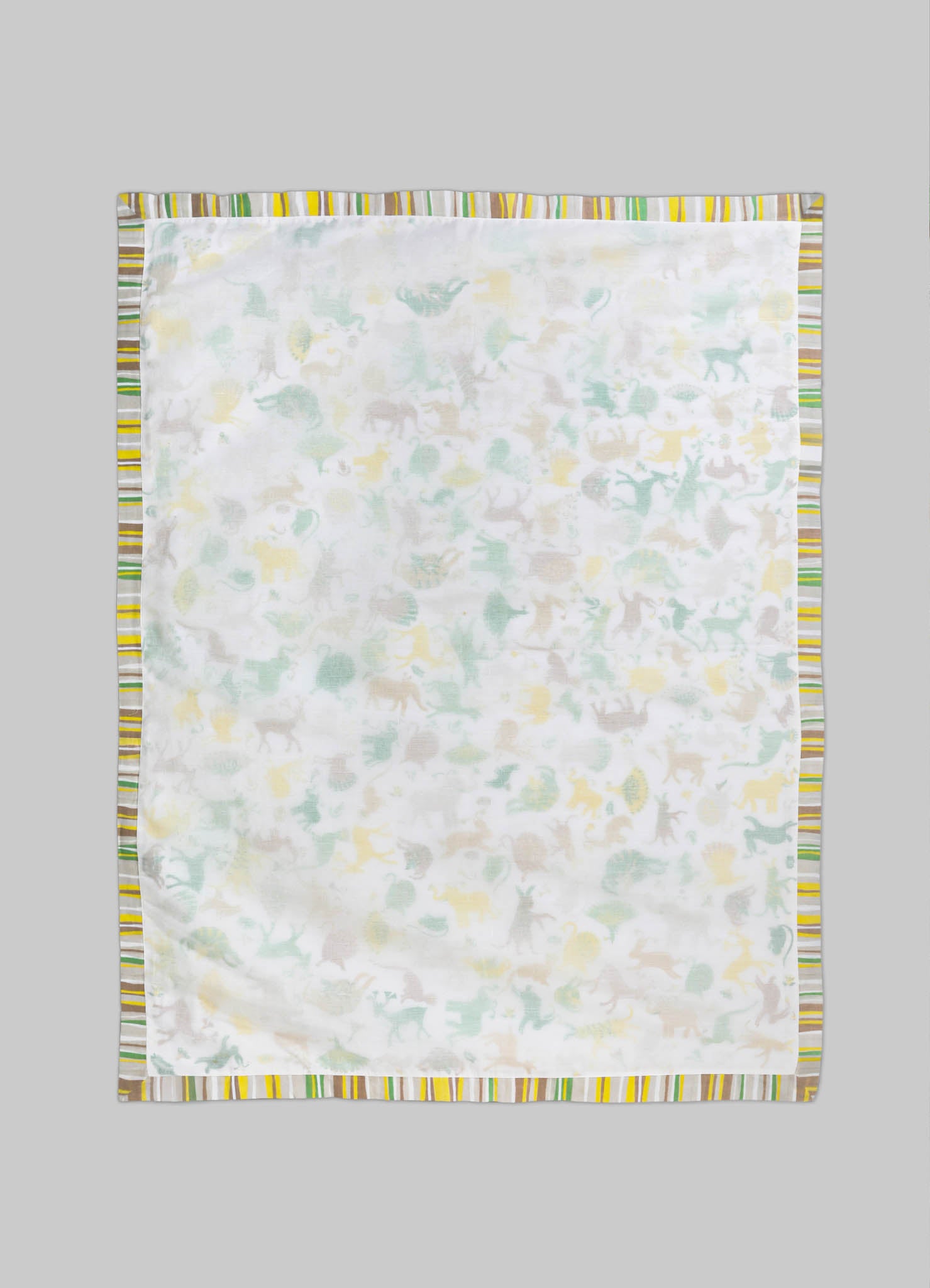 Cotton baby blanket with a pastel dinosaur print and a striped border in shades of yellow, green, and gray, displayed on a gray background.