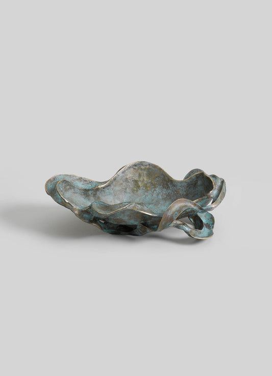 A metal bowl with an organic, irregular shape featuring a textured, aged finish in shades of blue and gray, with wavy, flowing edges and a rustic, handcrafted style.