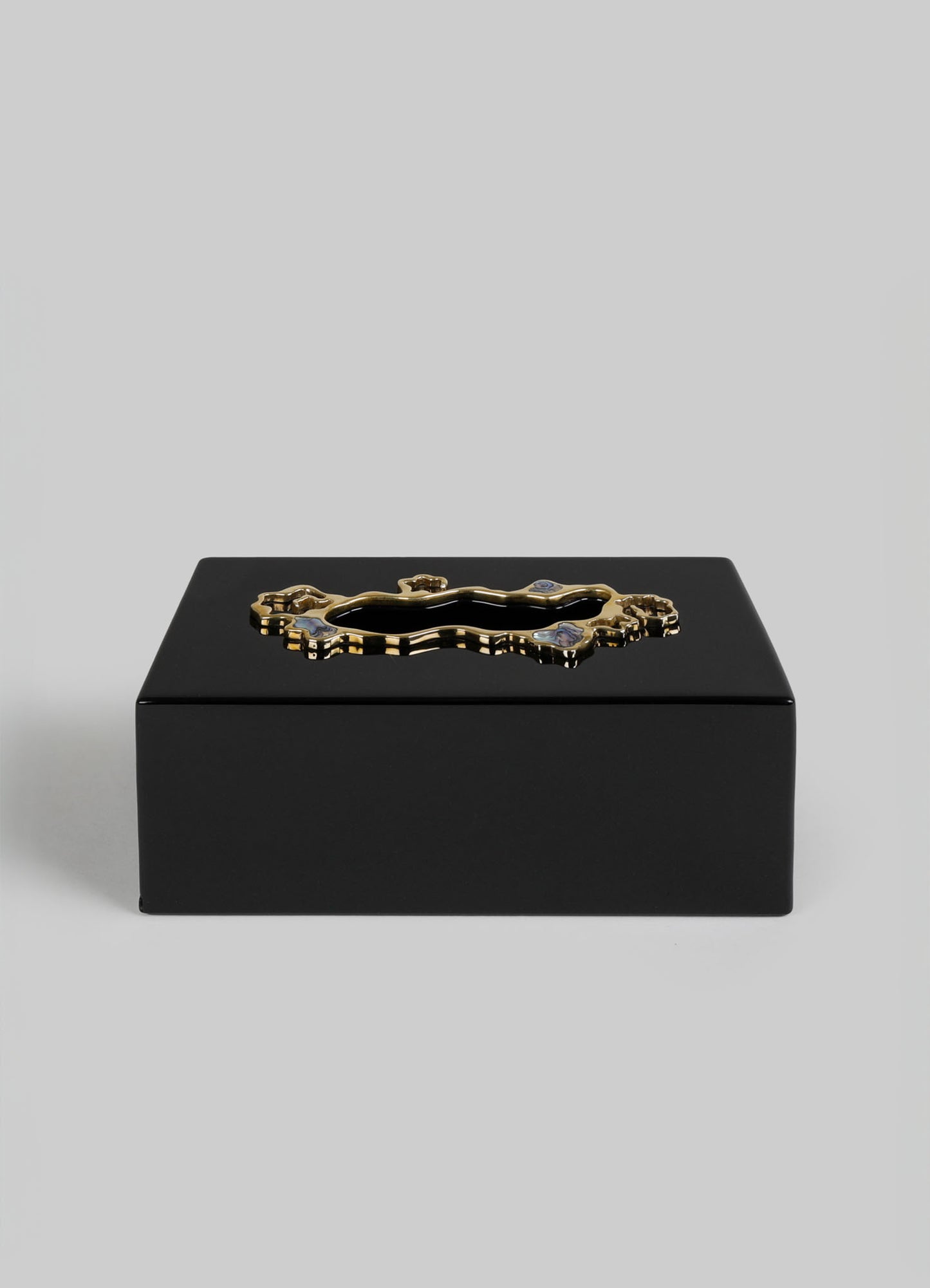 A black rectangular jewelry box with a glossy finish, featuring a gold-toned, ornate handle with intricate detailing on the lid.