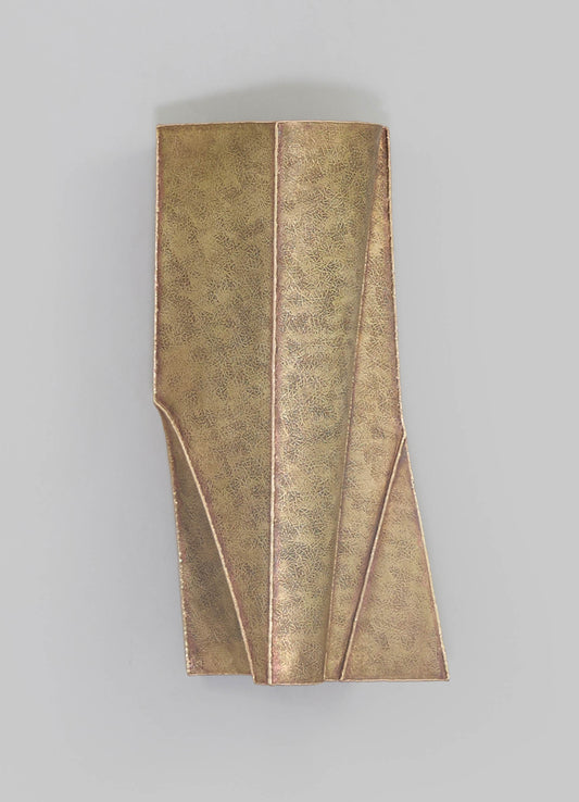 Brass vase with geometric panel design and a polished finish, featuring a combination of matte and shiny surfaces, presented against a neutral background.