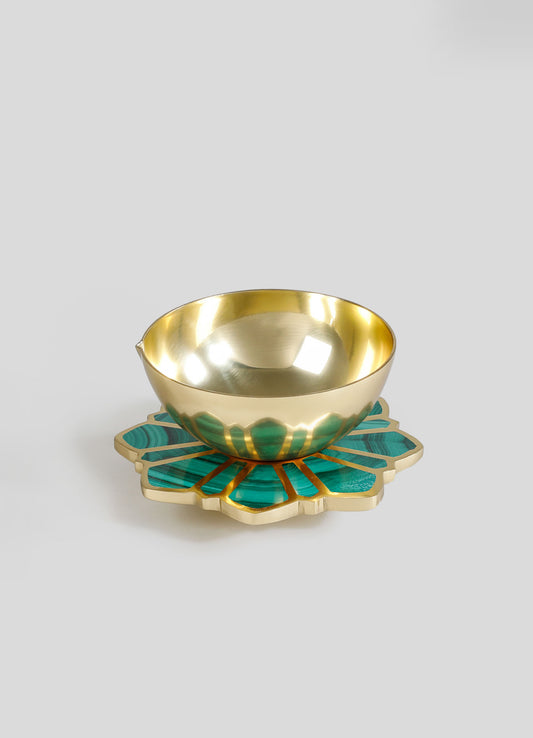 A decorative brass bowl with a polished gold finish, resting on a teal and gold resin inlay base with petal-shaped design, suitable for serving or display.