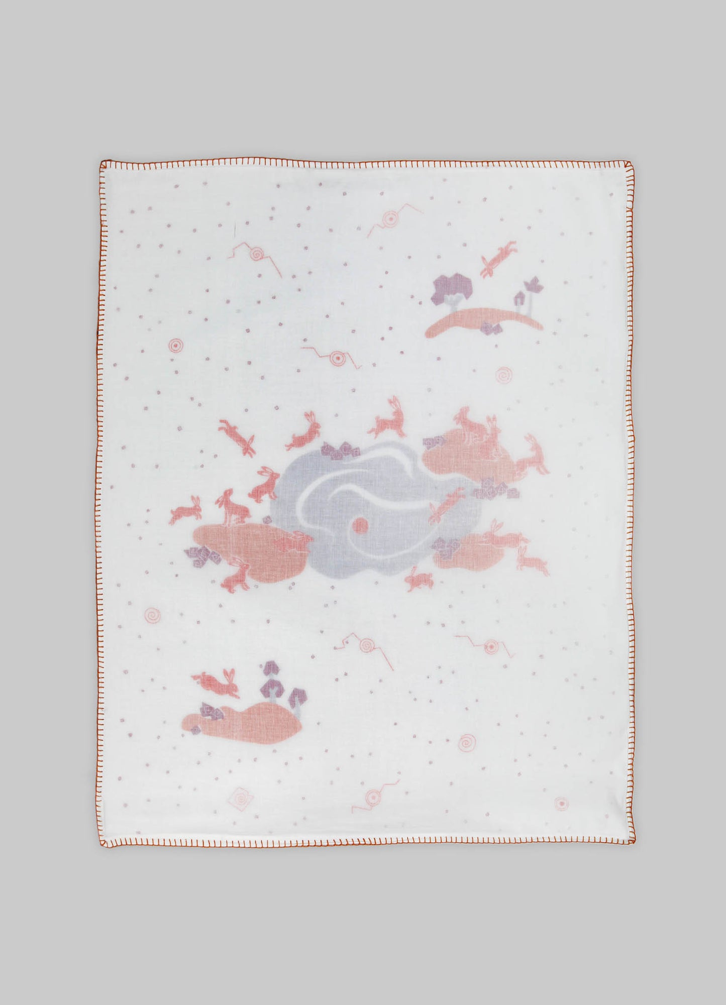 A white cotton or linen baby blanket with a whimsical, playful print featuring pastel-colored animals, rockets, and cloud motifs, bordered with a decorative red stitching. The design and colors suggest a soft, nursery-style aesthetic suitable for infants.