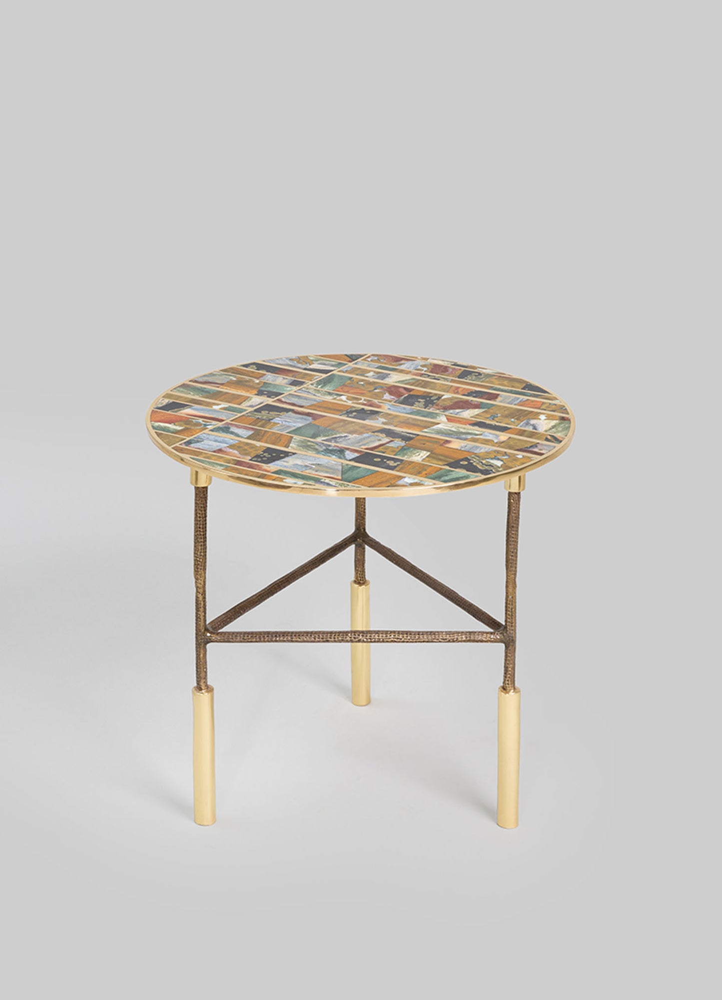 Round side table with a mosaic top featuring multicolored geometric patterns, supported by a metal frame with textured legs and cream-colored accents.