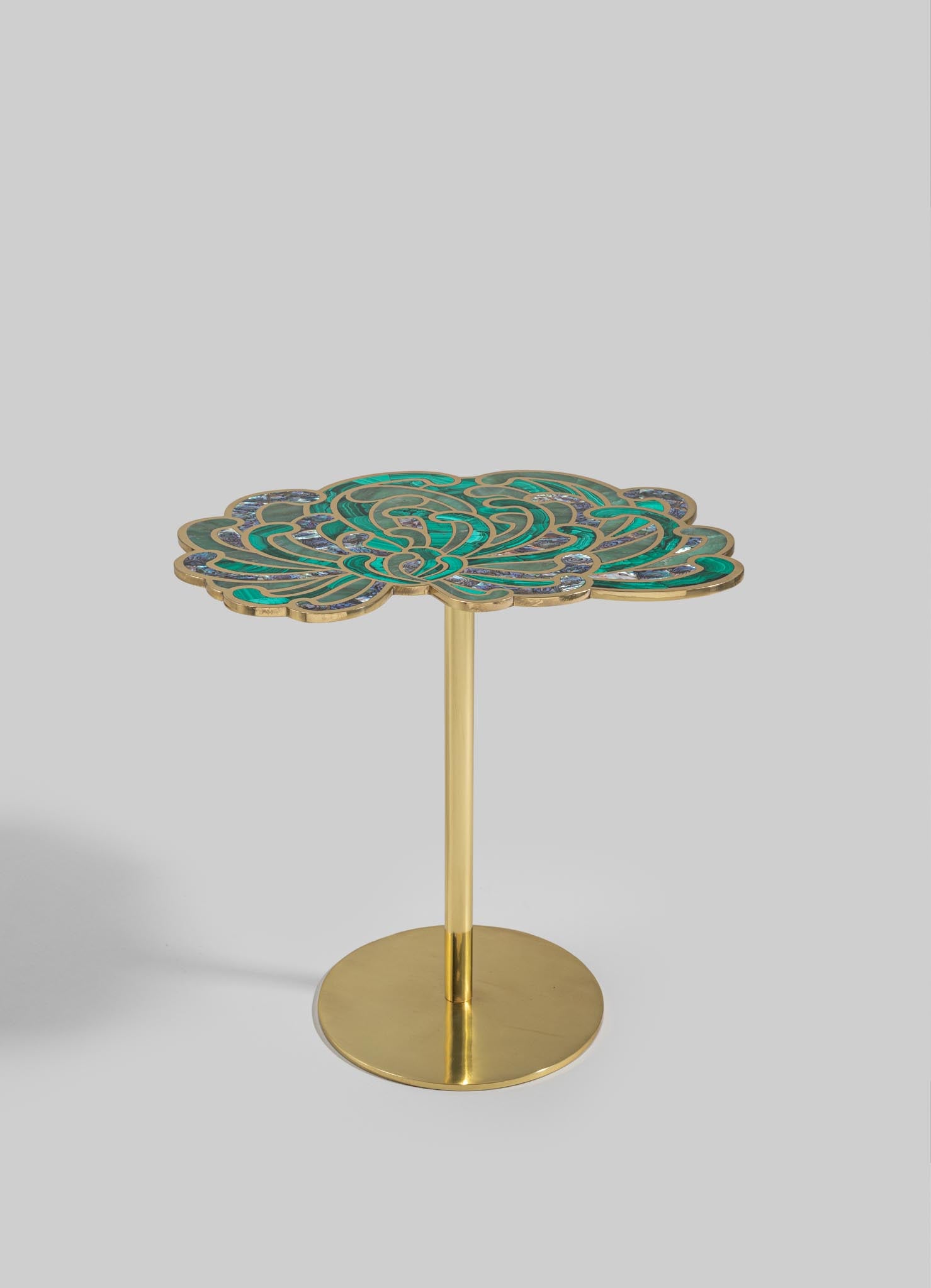 A side table with a circular brass base and a decorative top featuring an intricate, swirling pattern in shades of turquoise, green, and purple. The table combines a contemporary style with an artistic, handcrafted motif.