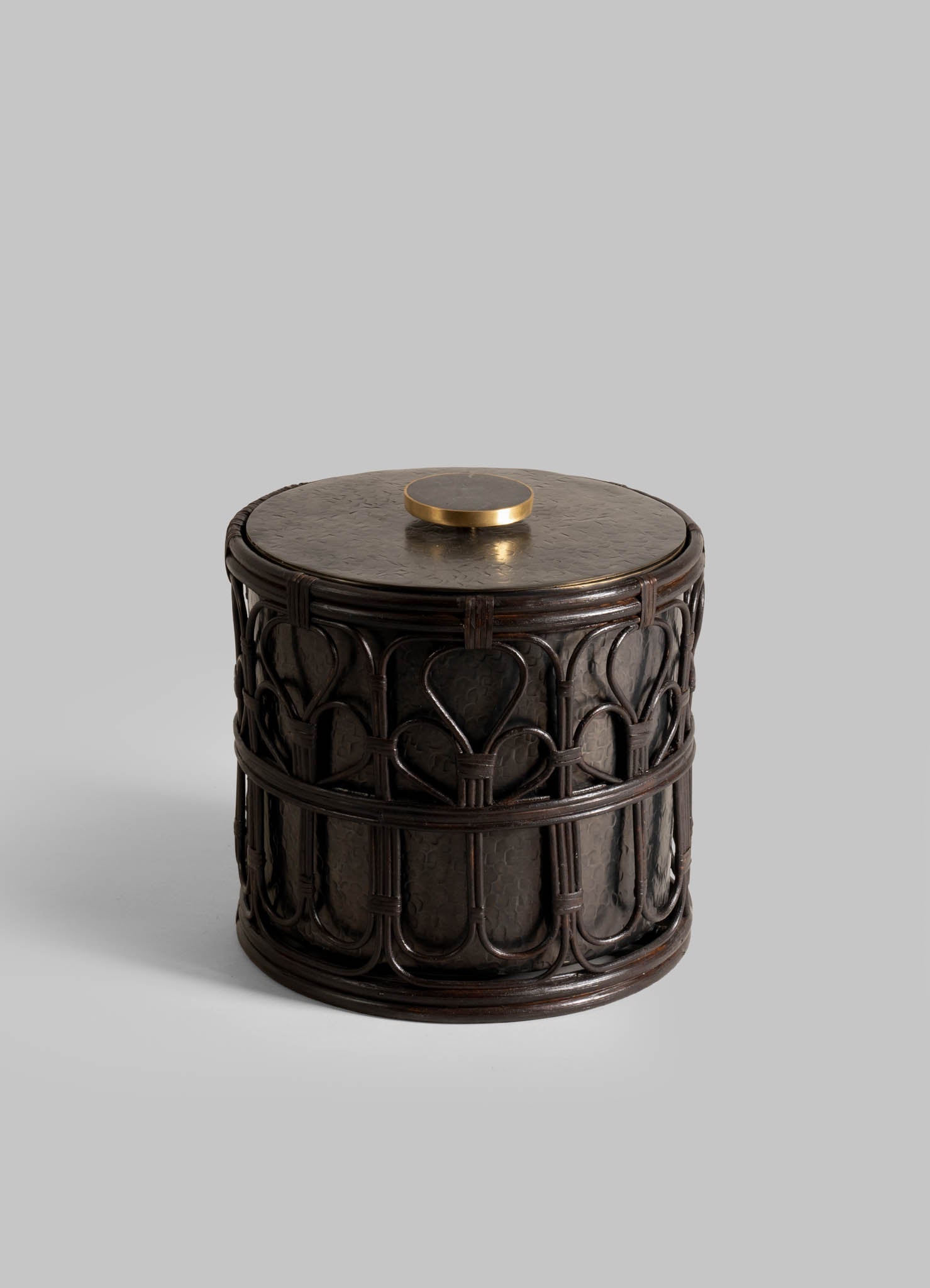 The Manipur Ice Bucket Large by VIYA is a round, dark wooden container with ornate carvings and a flat lid topped with a hand-beaten brass knob—an elegant upgrade to your barware accessories.