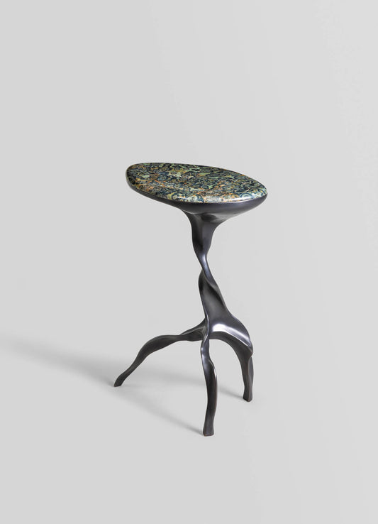 A modern artistic stool with a sculptural black metal base resembling twisted branches and an oval-shaped cushioned seat covered in a floral-patterned fabric with shades of blue, gold, and green.