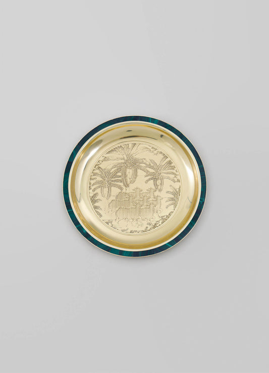 A decorative metal tray with an engraved tropical landscape featuring palm trees and animals, surrounded by a dark green and gold rim.