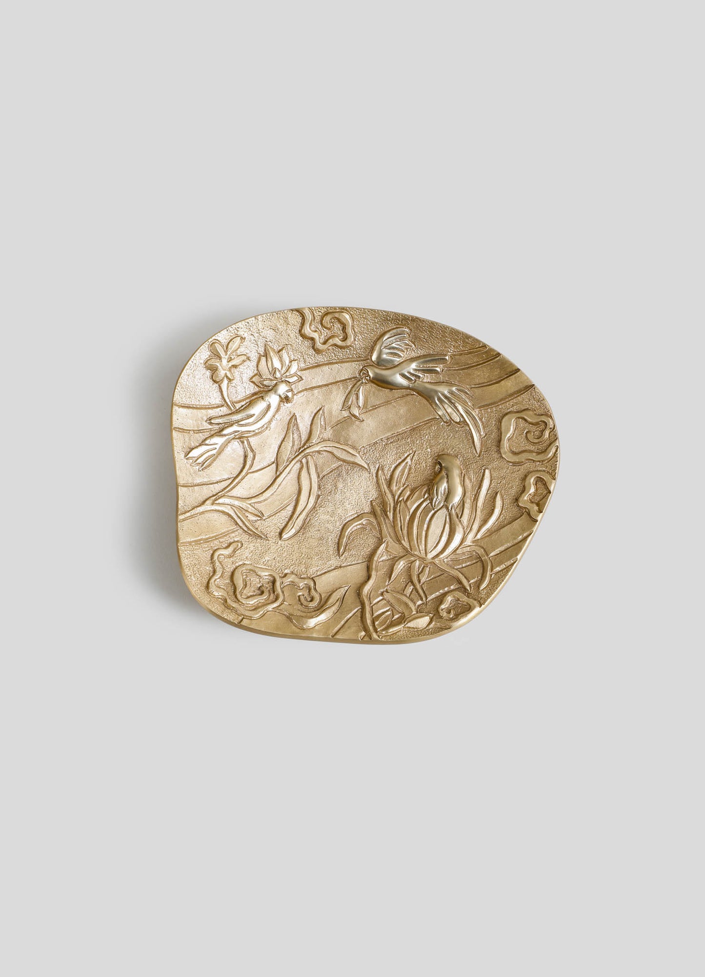 A decorative gold-toned tray with embossed floral and bird motifs, featuring a textured surface and rounded edges, designed in an ornate, handcrafted style.