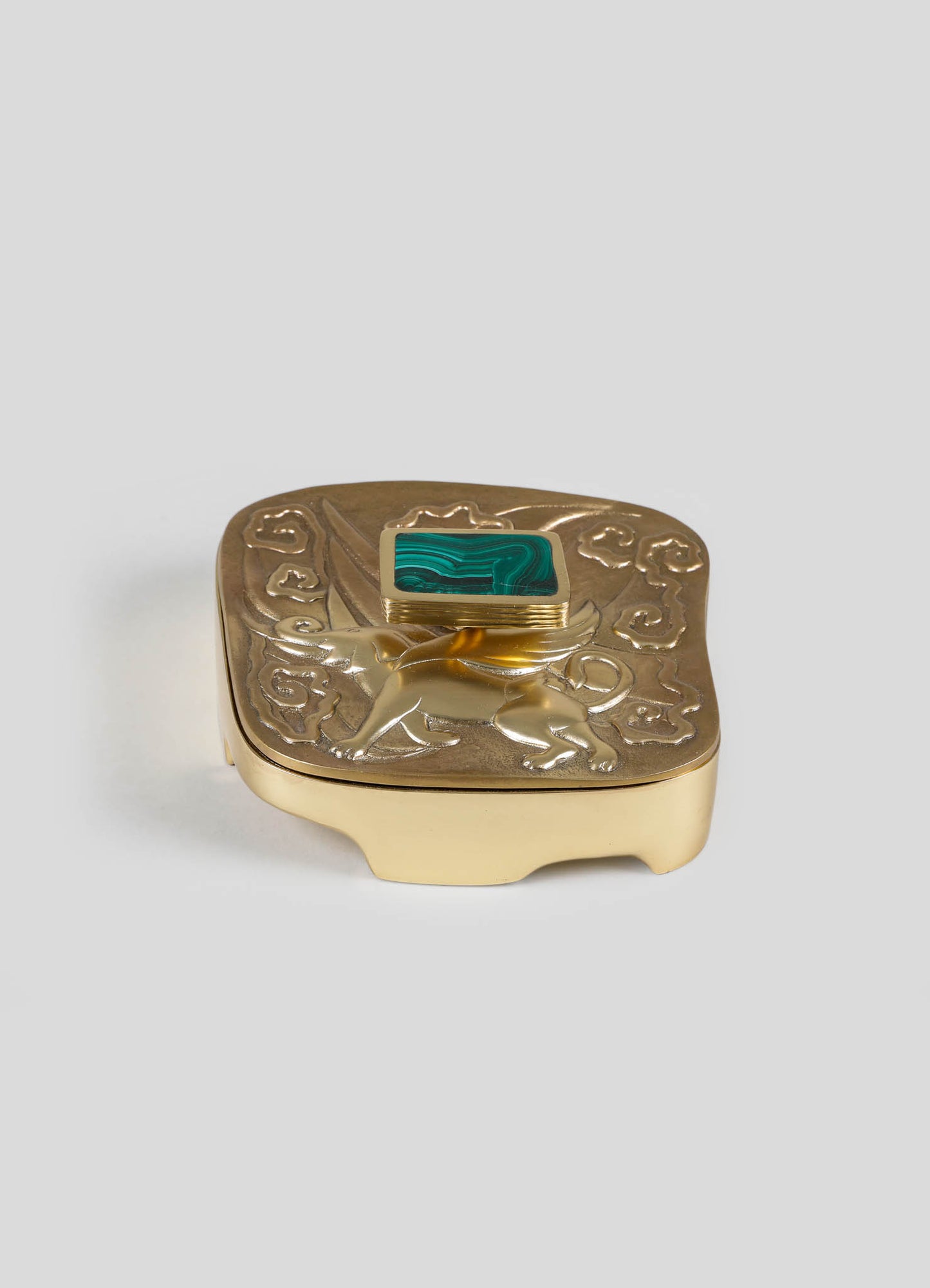A decorative gold-plated jewelry box with embossed lion motif and a square malachite stone on the lid, featuring intricate detailing and a rich, luxurious style.