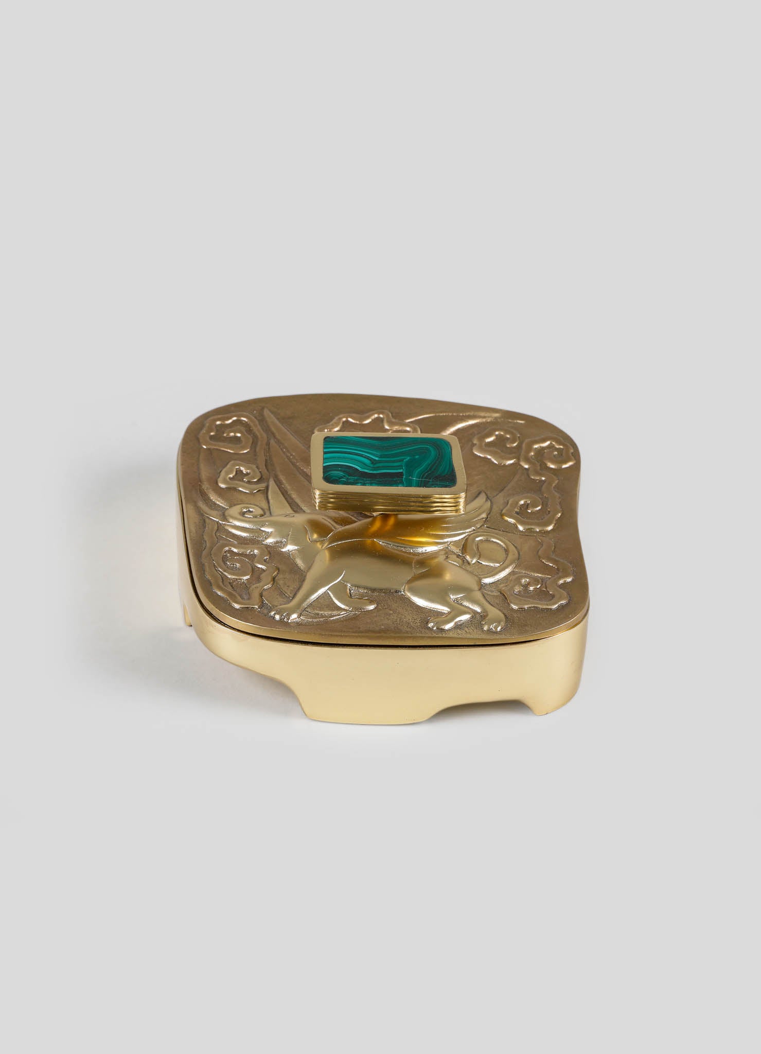 A decorative gold-plated jewelry box with embossed lion motif and a square malachite stone on the lid, featuring intricate detailing and a rich, luxurious style.