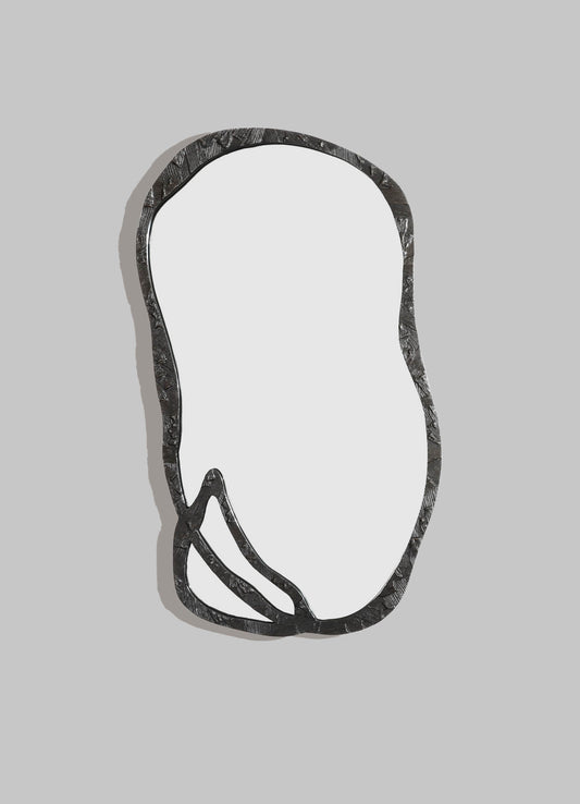 A decorative wall mirror with an irregular, organic-shaped metal frame featuring a textured surface in dark finish, mounted on a light gray background.