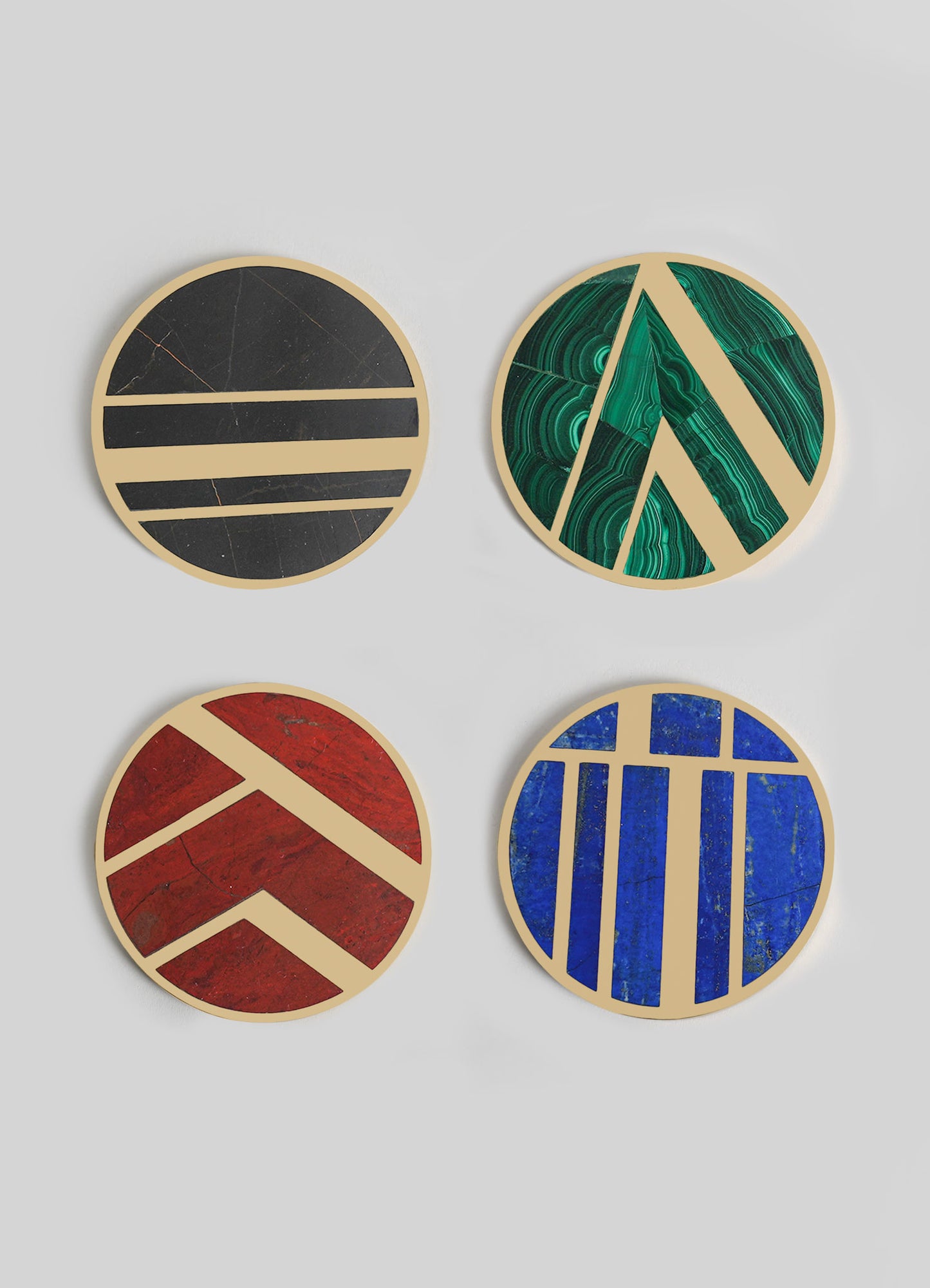 Four circular decorative wall panels featuring bold geometric patterns in contrasting colors; black and beige, green and beige, red and beige, and blue and beige. The panels are designed with vibrant, marbled textures and are suitable for contemporary interior decor.